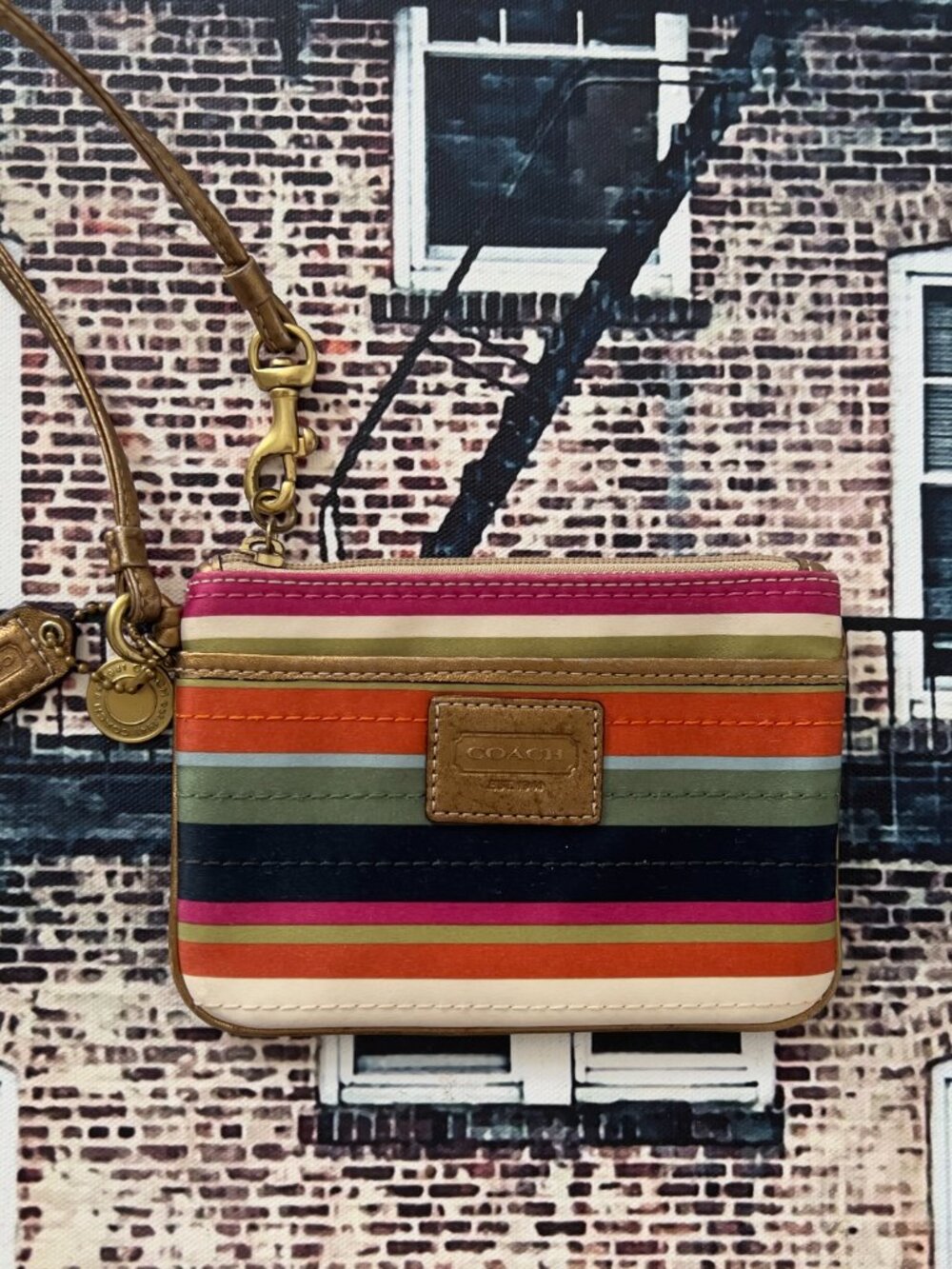 Coach wristlet from the Legacy collection features a vibrant multicolor stripe